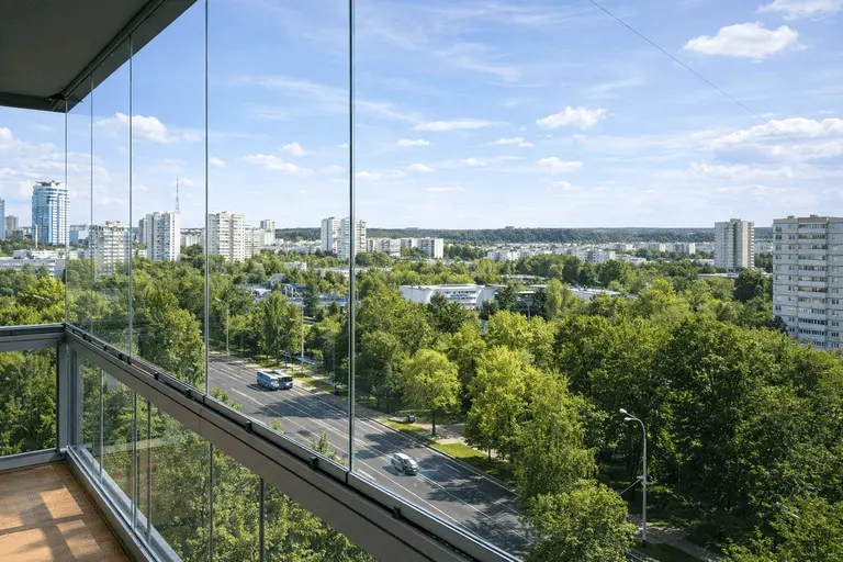 Безрамное остекление балкона с прозрачными стеклянными створками